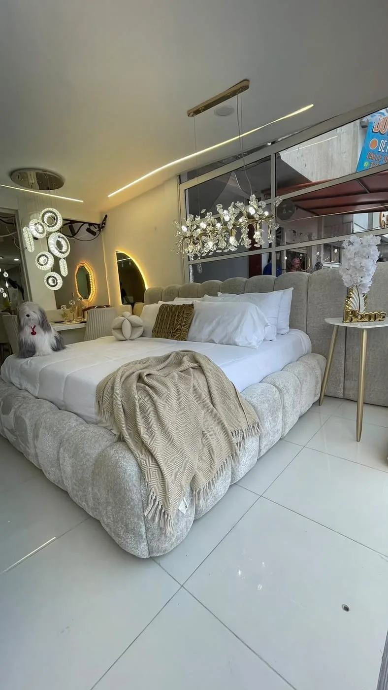 Cama con cabecero tapizado a pared completa en el showroom de Muebles Agar